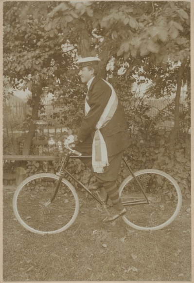 Foto Student auf einem Fahrrad, Tellermütze, Schärpe