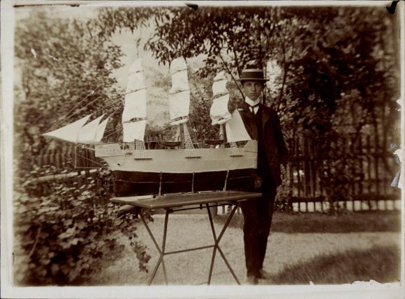 Künstler Ak Junger Mann mit einem Schiffsmodell, Portrait