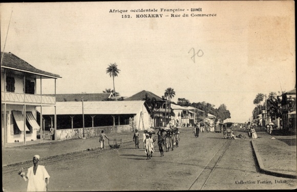 Ak Conakry Konakry Guinea, Straße mit Menschen, Geschäften, Palmen,  Guinea