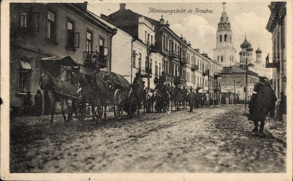 Ak Hrodna Grodno Weißrussland, Pferdewagen auf Straße, Häuserzeile, Kirchturm im Hintergrund