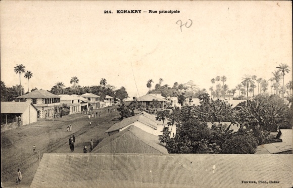 Ak Conakry Konakry Guinea,  Rue principale, Straßenansicht, Palmen, Gebäude