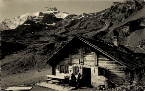 Ak Kiental Kanton Bern, Berglandschaft, Holzhaus, zwei Personen, Schneeberge im Hintergrund