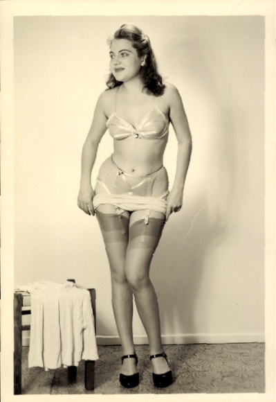 Foto stehende Frau in Unterwäsche, Strumpfhalter, beim Ankleiden