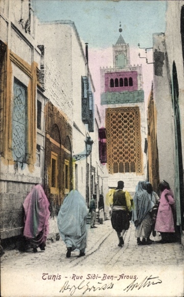 Ak Tunis Tunesien, Gasse in  Menschen in traditioneller Kleidung, Minarett im Hintergrund