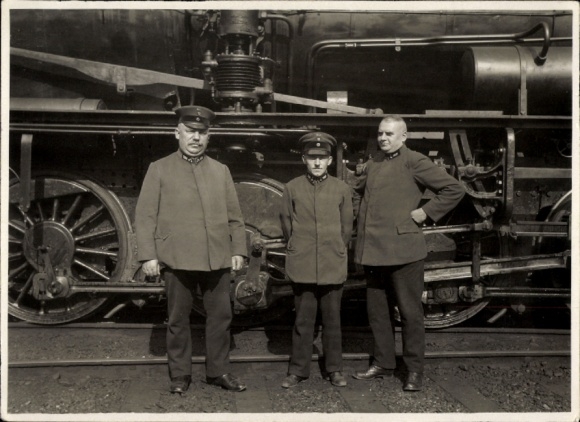 Foto drei Eisenbahner in Uniform vor einer Lokomotive